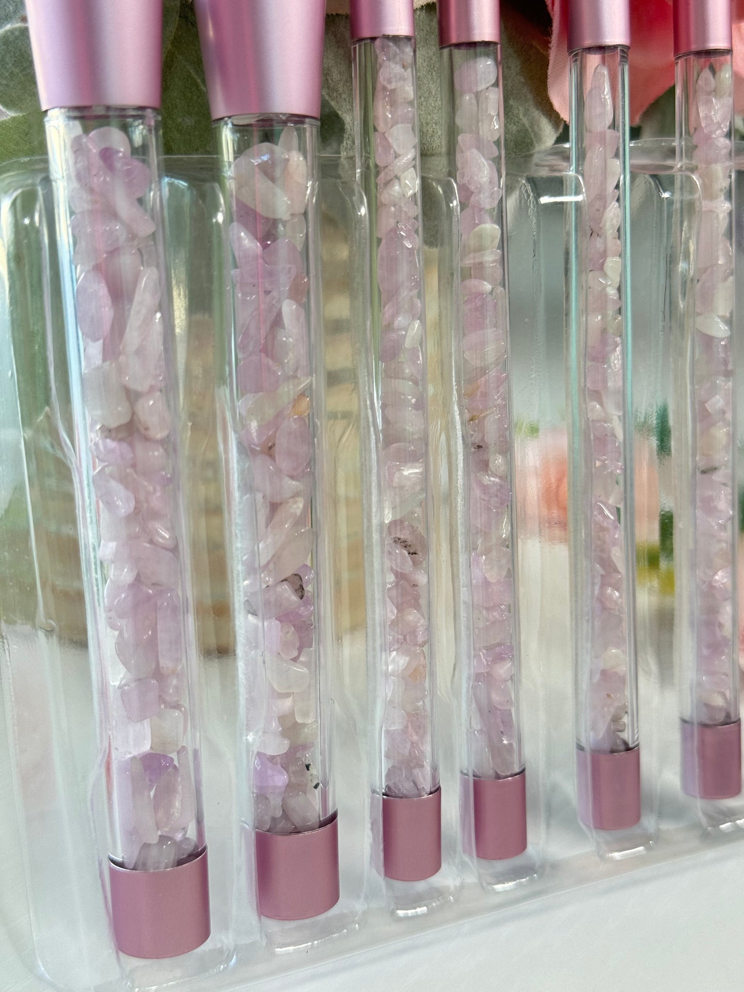 Makeup brush set with Kunzite crystal chips in the handles. Includes a clear pouch with glitter flakes. Set includes all brushes seen in photo